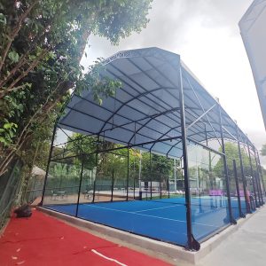 Custom outdoor Padel court roof structure and canopy over a blue playing surface, supplied by Toshimi Sports.