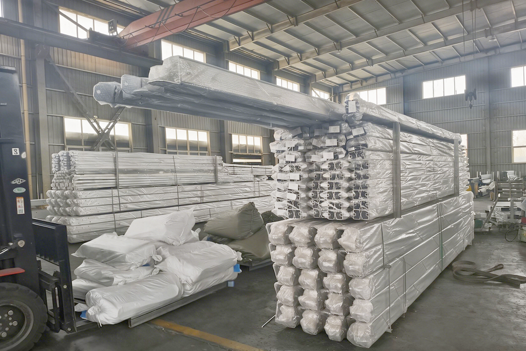 Direct Manufacturer Aluminum Frame Production Line - Toshimi Sports Neatly stacked aluminum frame profiles on the production line at the Toshimi Sports direct manufacturing facility, ensuring high-volume supply and quality control for custom sports tents.