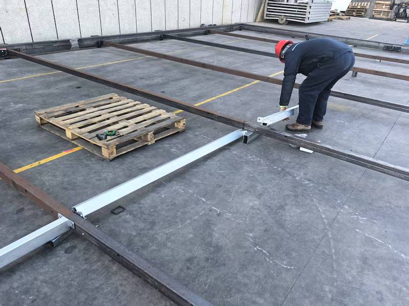 Worker assembling Toshimi Sports modular hot-dip galvanized steel frame for padel court suspension platform
